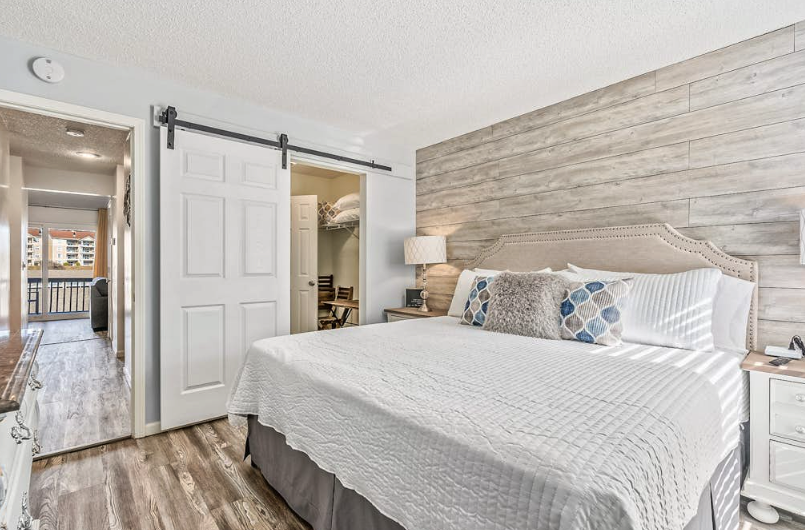 Stylish vacation rental bedroom with barn door and shiplap wall